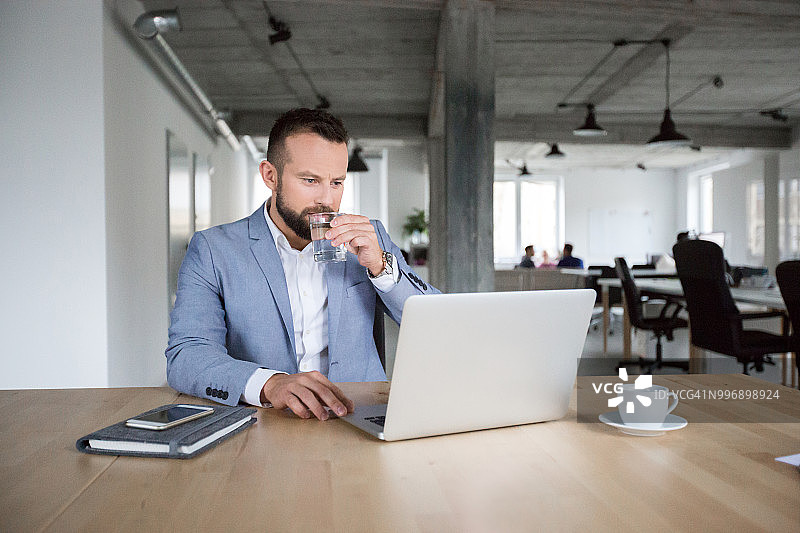 商人忙于用笔记本电脑工作图片素材