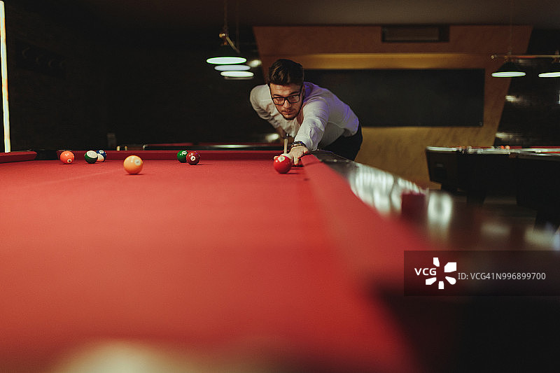 快乐的年轻男人在室内玩台球图片素材