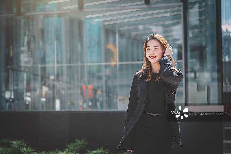 在街上微笑行走的亚洲女商人图片素材