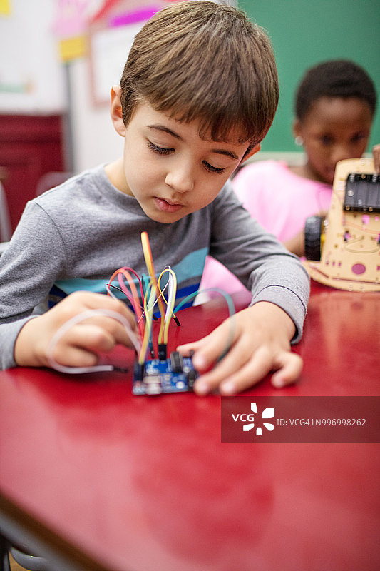 在教室里做科学项目的可爱男孩图片素材