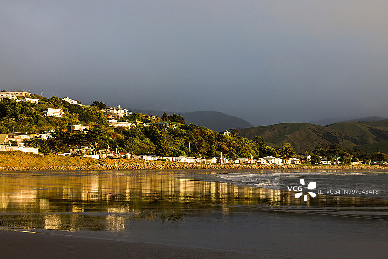 怀拉拉帕卡斯尔波因特海滨的金色日出光芒与沙滩上的倒影图片素材