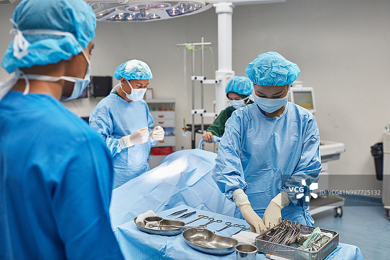 医生在后台与外科医生一起整理工具图片素材