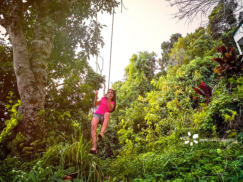 年轻女孩在户外玩绳索秋千图片素材