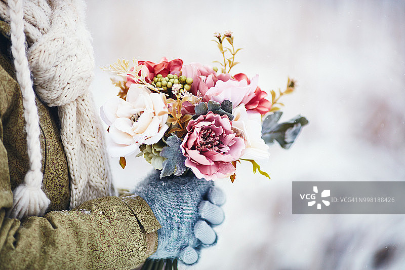 女人在雪中手捧鲜花图片素材