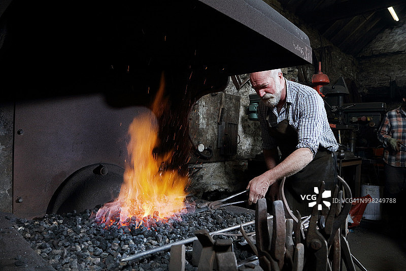 铁匠在锻造车间里用火炉加热金属图片素材