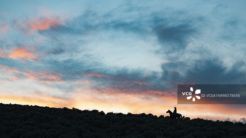 日落时分骑马牛仔的轮廓图片素材