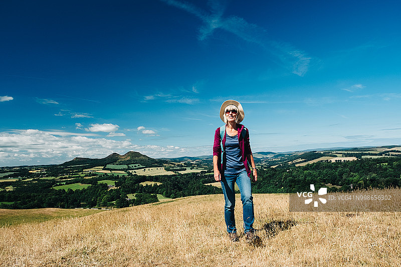 在草地上行走的活力老年妇女图片素材