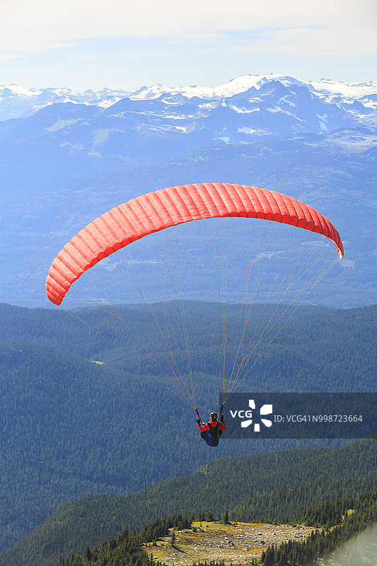 在加拿大不列颠哥伦比亚省惠斯勒山顶上玩滑翔伞的人图片素材