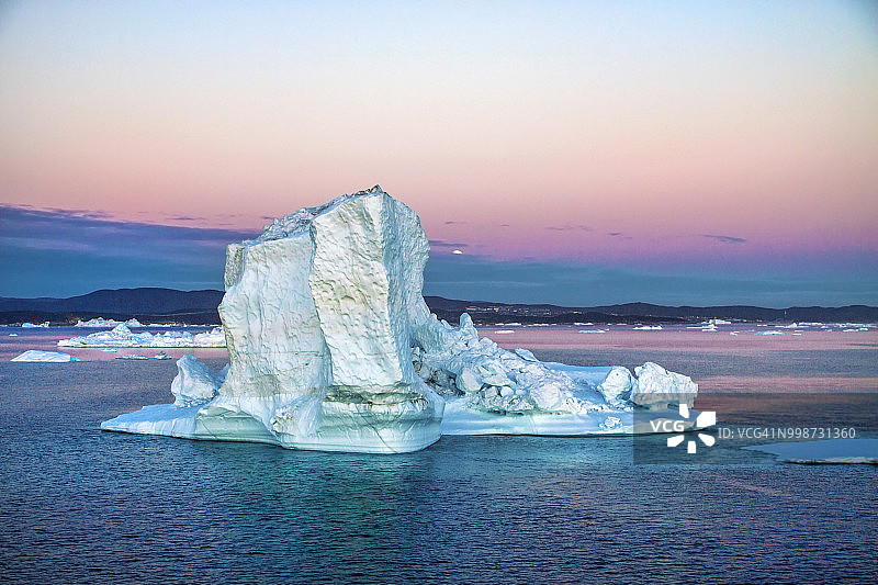 格陵兰发现湾，伊卢利萨特康格路亚冰川（又名塞梅克库雅雷格）的漂浮冰山日落景色图片素材