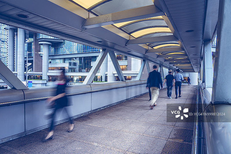 人们走过有盖人行天桥的模糊景象图片素材