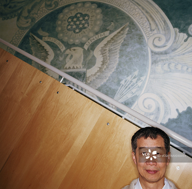 年长的男人站在墙壁壁画前，高处图片素材