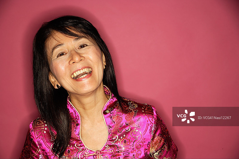 穿着旗袍、笑着的中年妇女图片素材