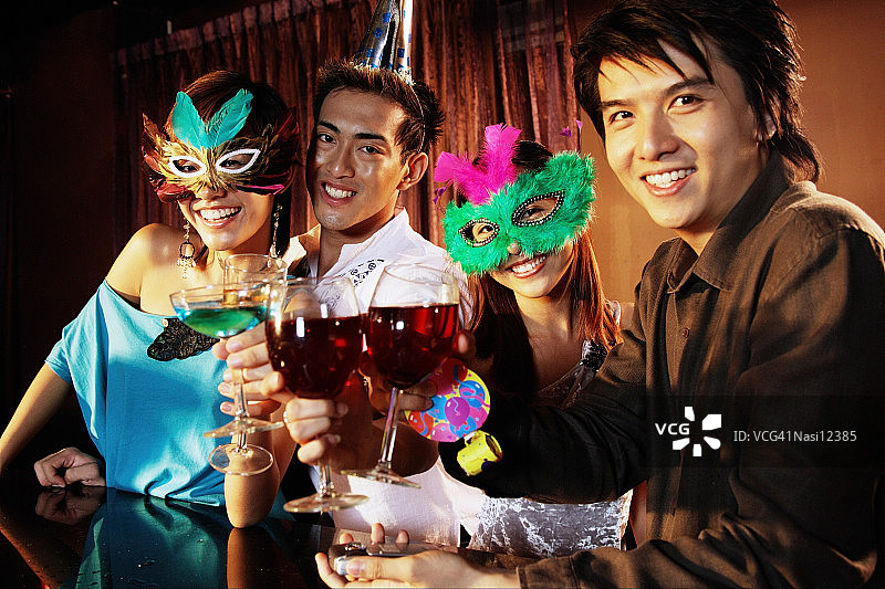 戴着口罩、拿着饮料、看着镜头的情侣图片素材