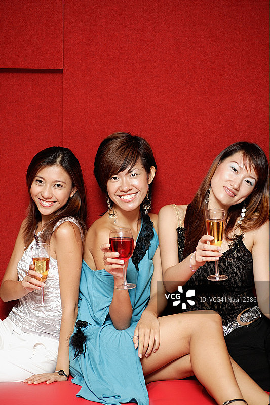 拿着饮料对着镜头微笑的年轻女人图片素材