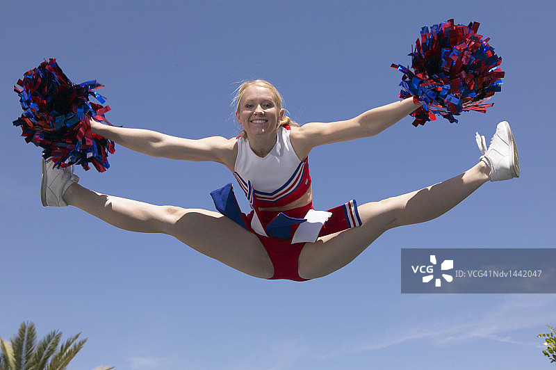 手持绒球在空中劈叉的啦啦队图片素材