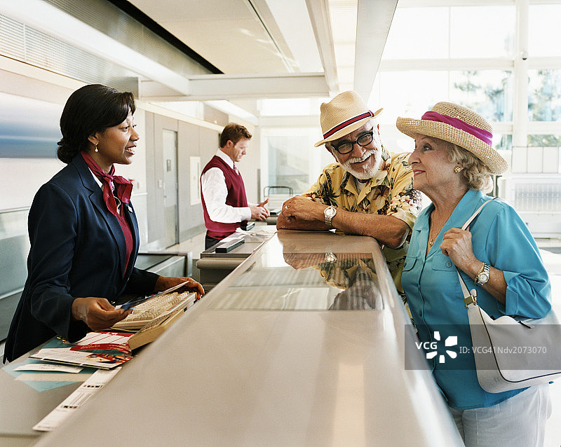 接待员在机场办理登机手续时与乘客交谈图片素材