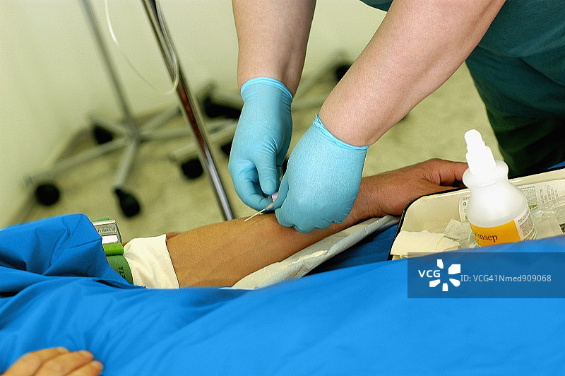 护士将静脉注射针头插入患者手臂特写图片素材