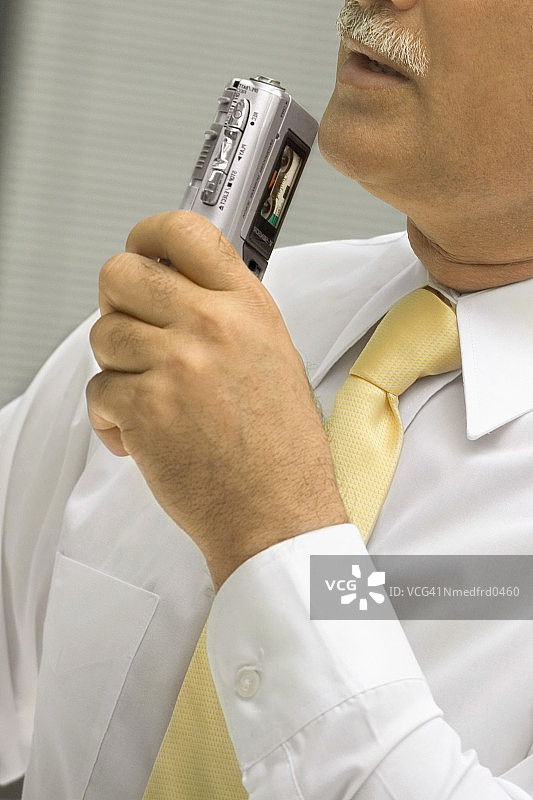 商人对着小型录音机口述图片素材