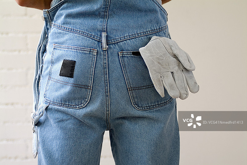 穿着工作服、手套从后口袋伸出的人的背影图片素材
