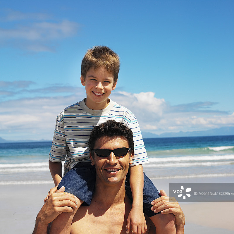 父亲背着儿子(8-9岁)的正面肖像图片素材