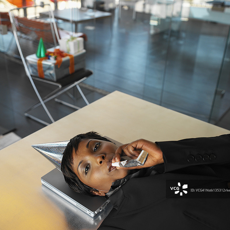 女商人头靠笔记本，吹口哨庆祝派对图片素材