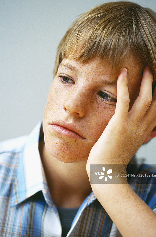 手托着头的男孩特写图片素材