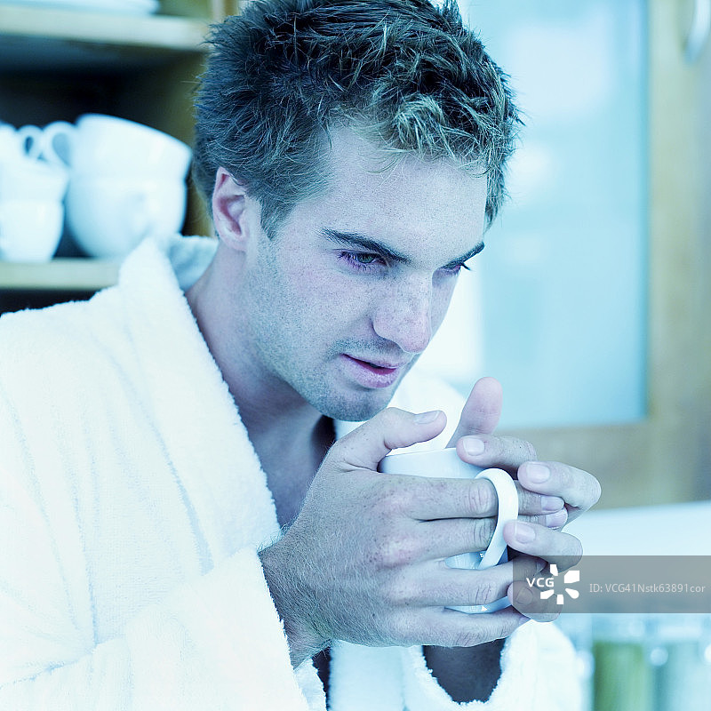 手捧咖啡杯的生病年轻男人肖像图片素材