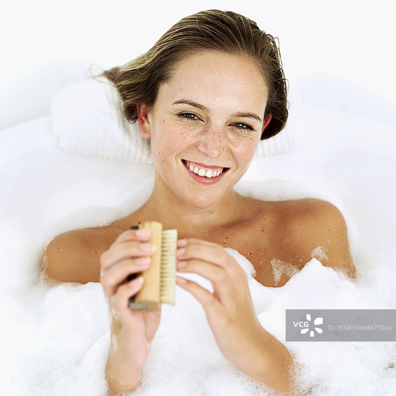 在泡泡浴中打磨指甲的女性的俯视图图片素材