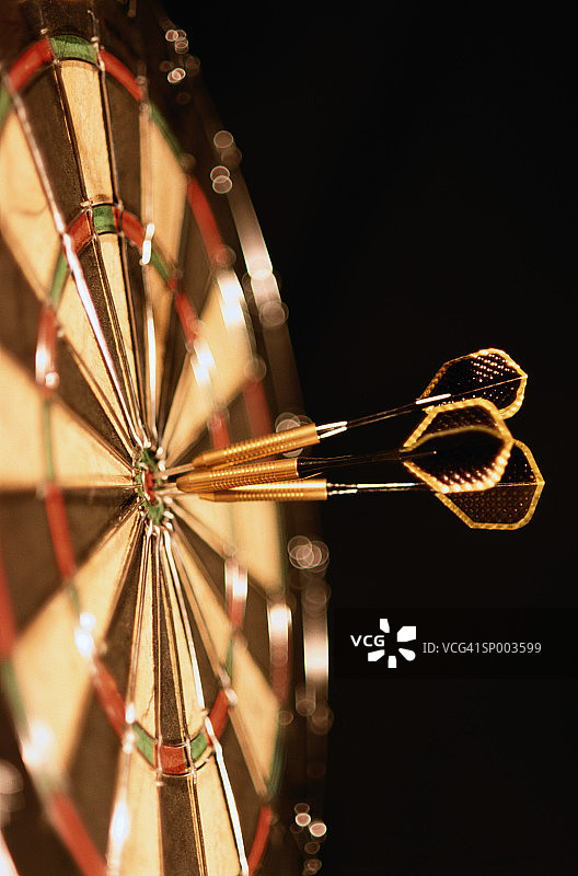 射中靶心的三支飞镖特写图片素材