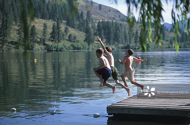 三个男孩跳入湖中图片素材