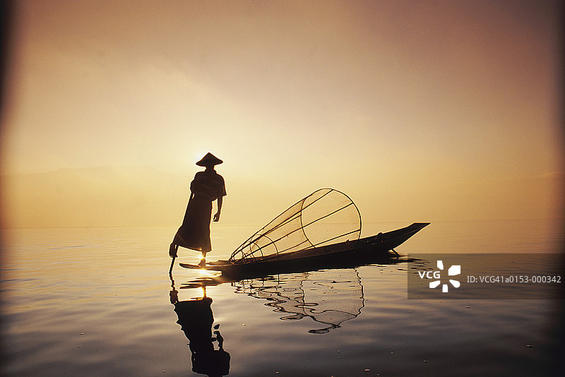 日落时在湖上的渔夫图片素材