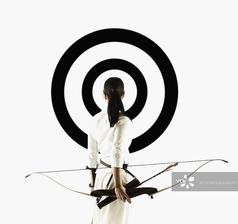 年轻女子持十字弓瞄准目标图片素材