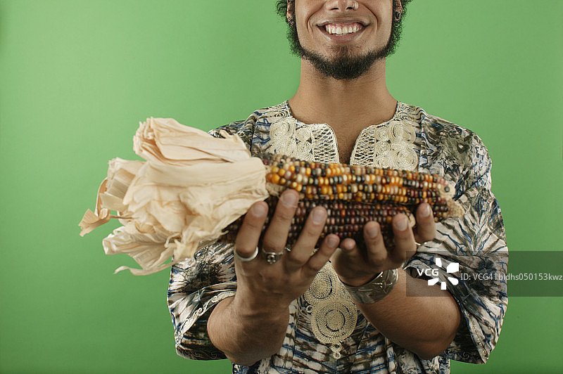 年轻男子拿着一个印第安玉米图片素材