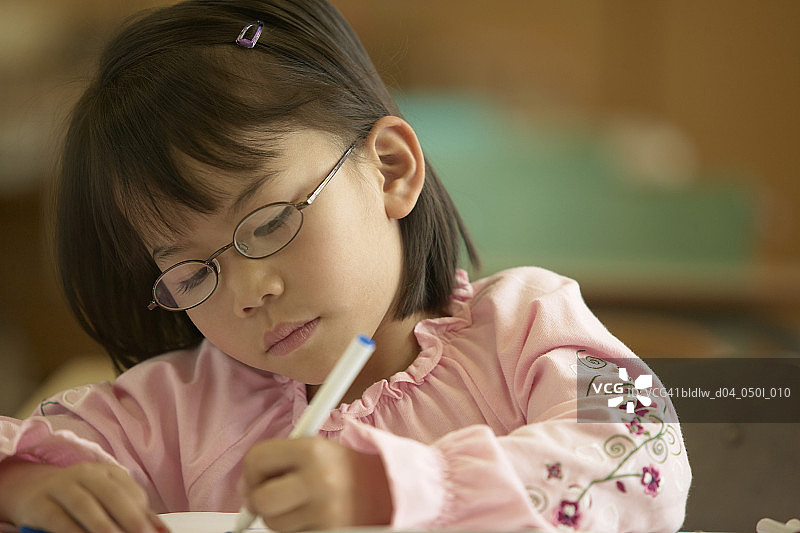 女孩在教室里涂色的特写图片素材
