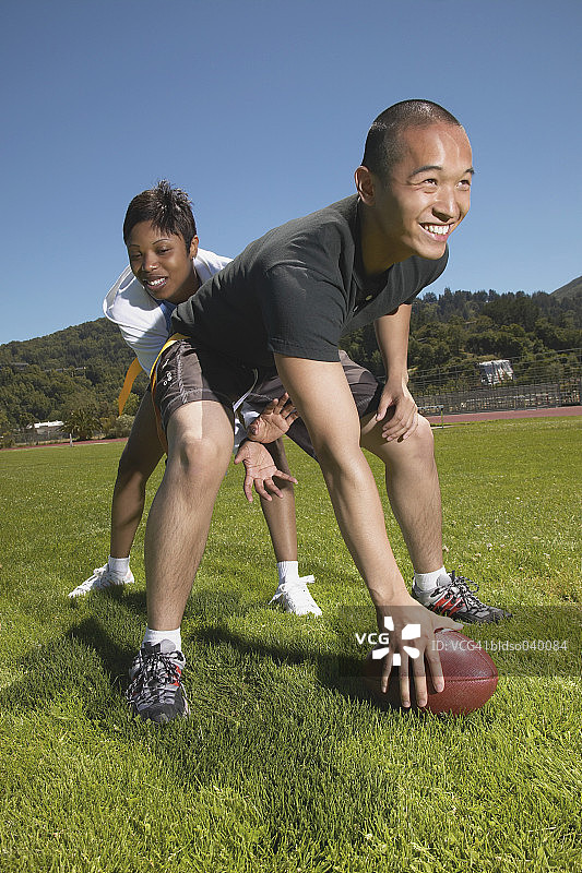 年轻男子和年轻女子在踢足球图片素材