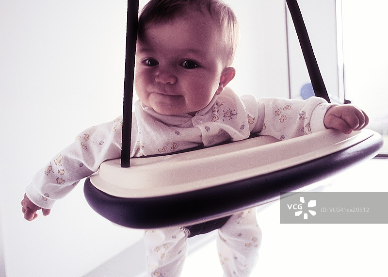 坐在摇椅上的六个月大的女婴图片素材
