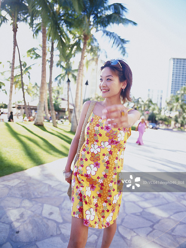 在夏威夷街道上散步的年轻女人图片素材