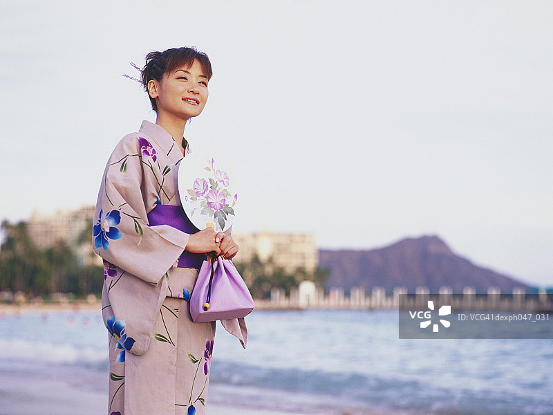 在海滩上身穿日式和服的年轻女人肖像图片素材