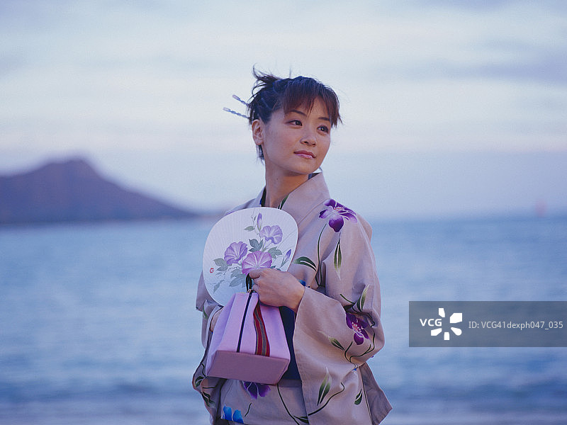 在海滩上身穿日式和服的年轻女人肖像图片素材