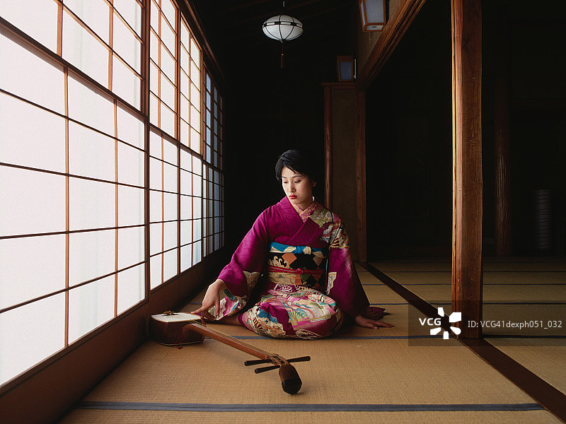 穿着和服弹奏三味线的年轻女人图片素材