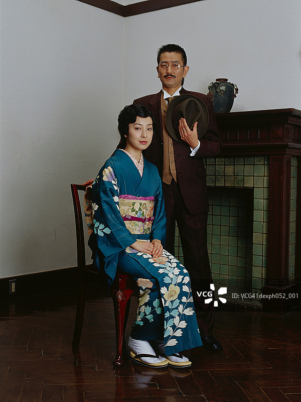 传统日式夫妇，女人坐在椅子上，男人站立图片素材