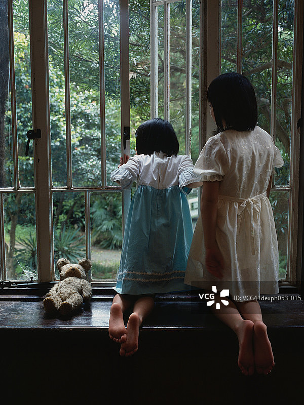两个女孩倚窗望外背影图片素材