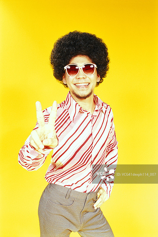 跳舞姿势的年轻亚裔男子，蓬松发型图片素材