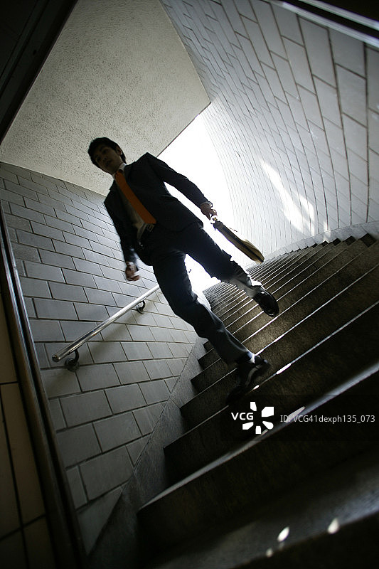 低角度视角：走下楼梯的年轻商人图片素材