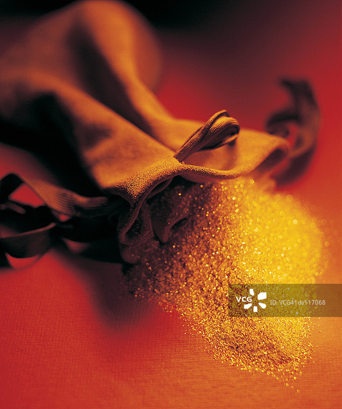 从麻袋中洒落的金粉图片素材