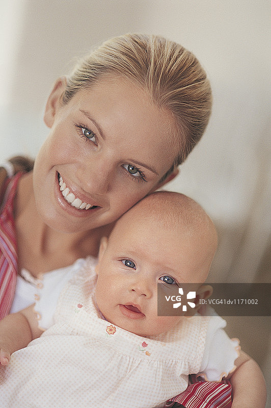 抱着新生婴儿的年轻母亲肖像图片素材