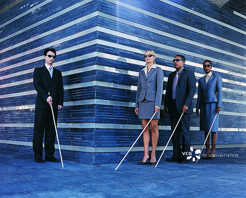 盲人商务人士拄着白色手杖排队行走图片素材