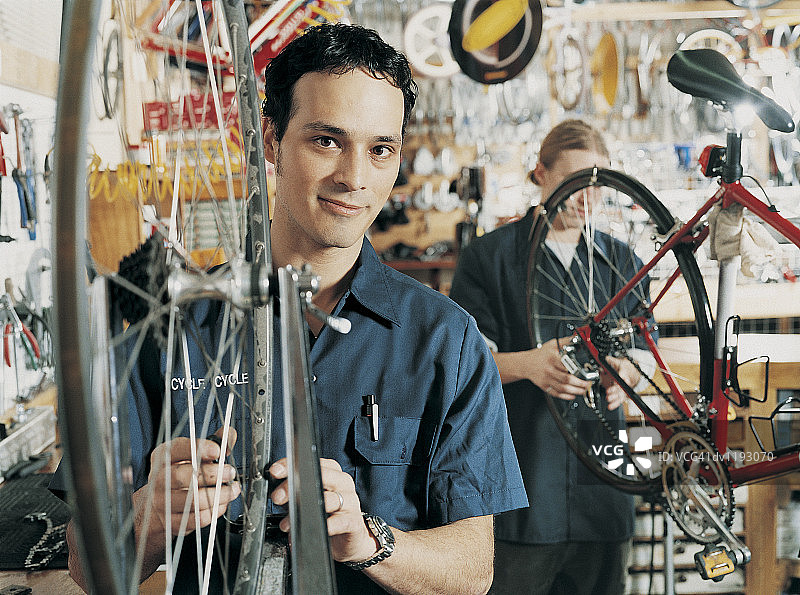 在自行车店工作的年轻男子肖像图片素材
