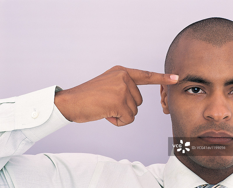 指向自己头部的年轻商人肖像图片素材