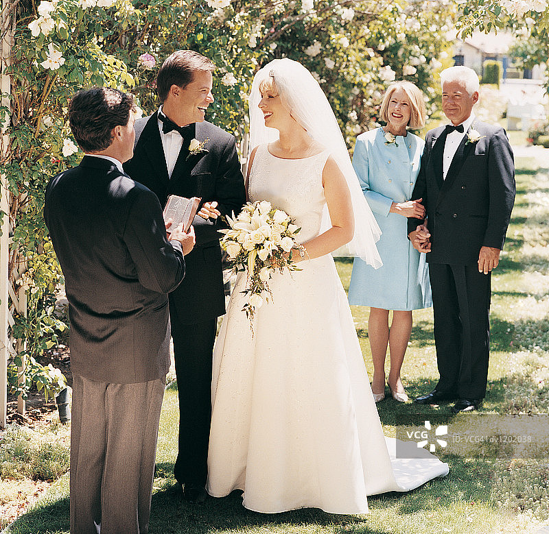 花园结婚典礼上与父母合影的新娘和新郎图片素材